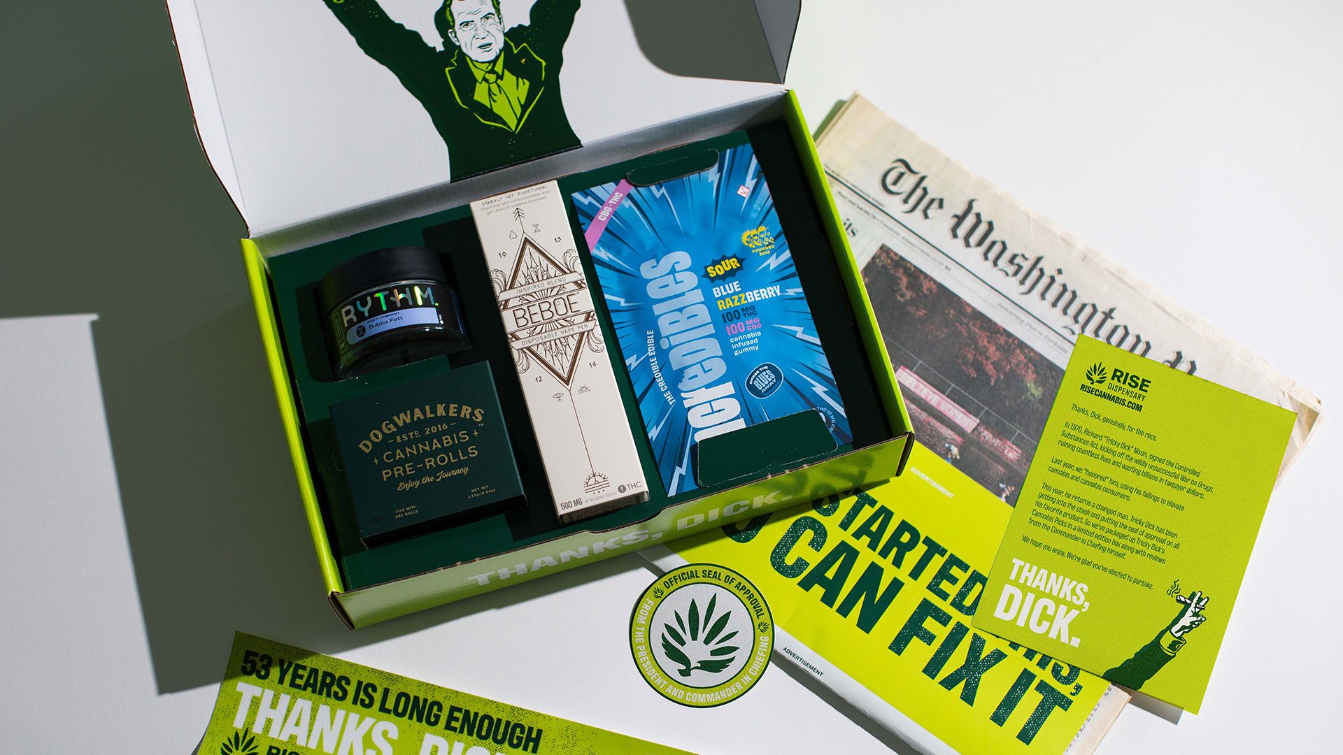 A box full of weed products with Nixon, a newspaper, postcard and button with his illustration